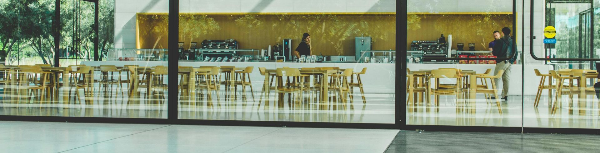 Contemporary café with glass walls showcasing a sleek interior design in Cupertino, California.